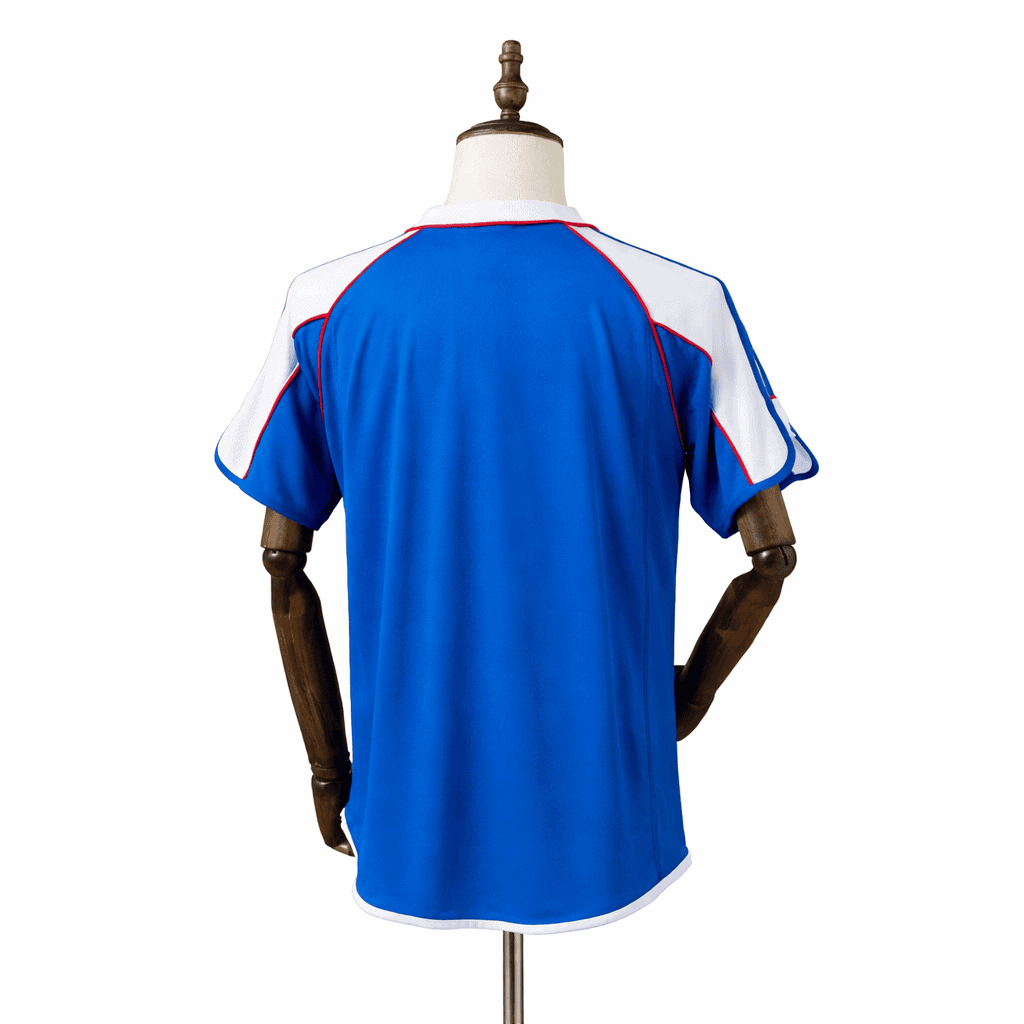 IMG-7423 | AE JERSEY Back view of a royal blue athletic jersey with white shoulder panels and red piping, on a mannequin.