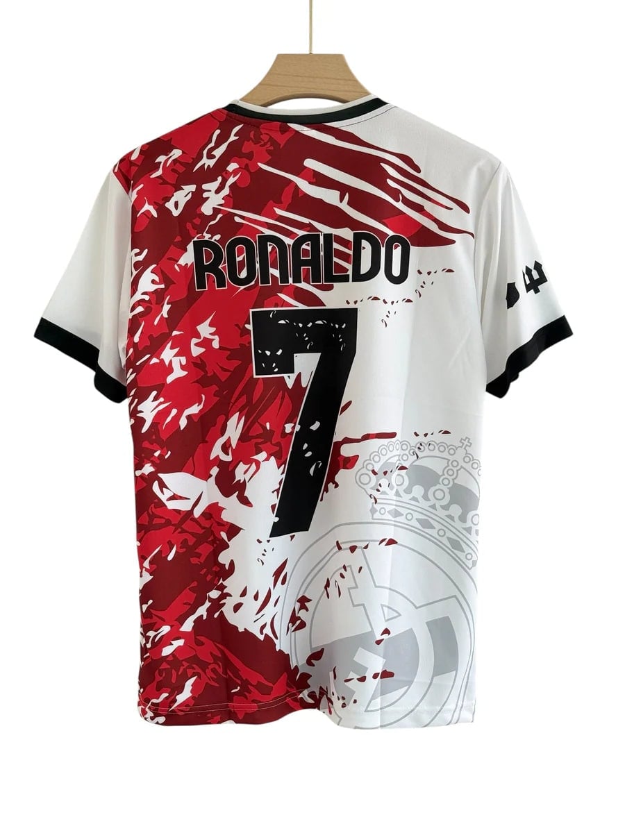 IMG_4039_900x_f2ed8c6a-e505-4974-8666-89cea8803e24 | AE JERSEY Back of a white and red graphic soccer jersey hanging on a wooden hanger, with 'RONALDO' and the number 7 and a crown motif on the design.