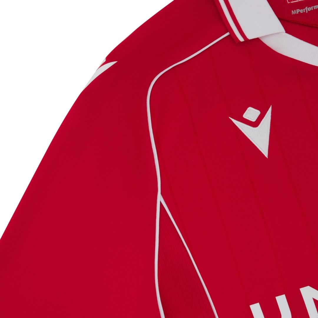 J7 | AE JERSEY Close-up of a red sports jersey with white piping and a white diamond-shaped logo on the chest area.