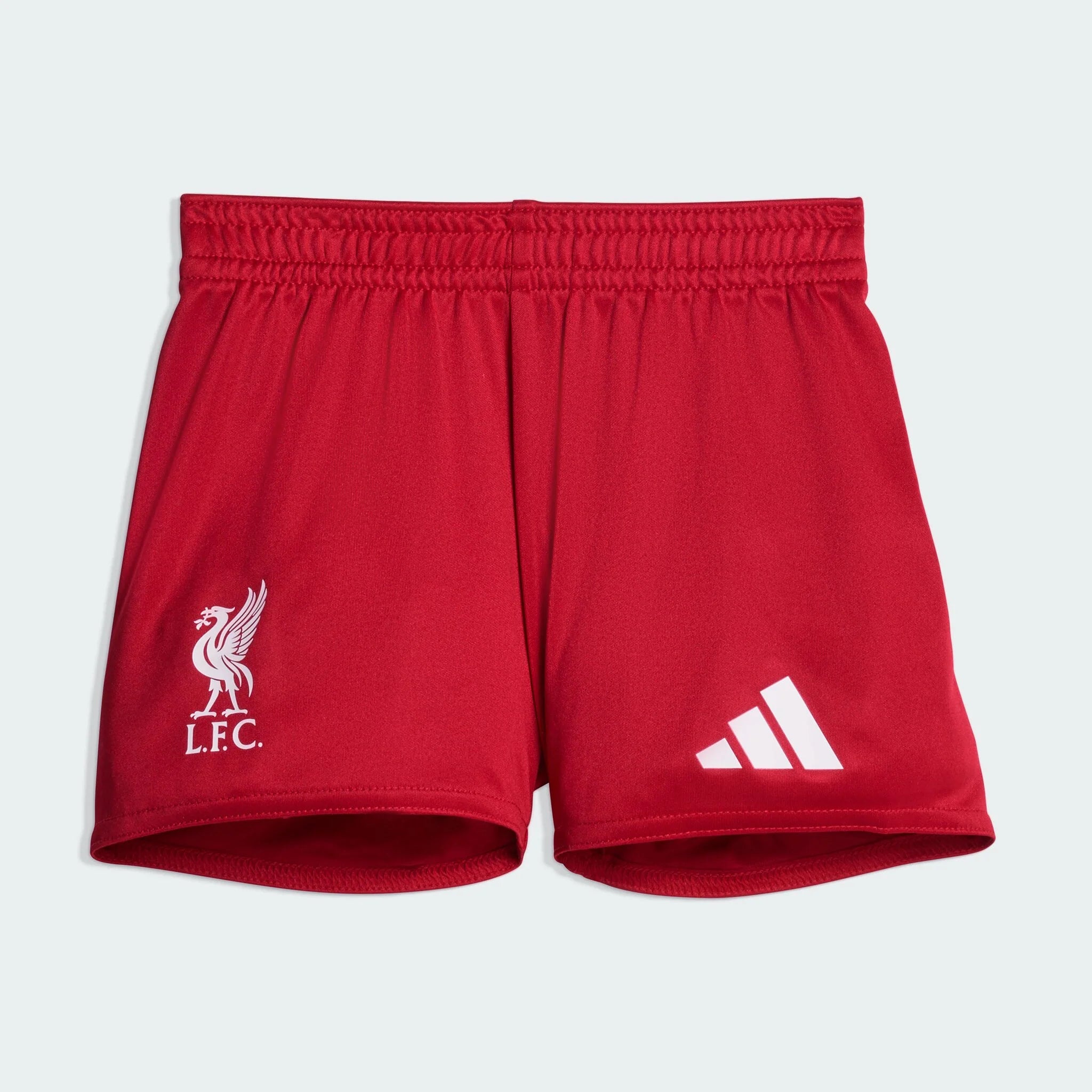 JV6443_Fbp_Flat_eCom-lowres | AE JERSEY Close-up of red athletic shorts showing a white Liverpool FC crest on the left leg and white Adidas stripes on the right leg.