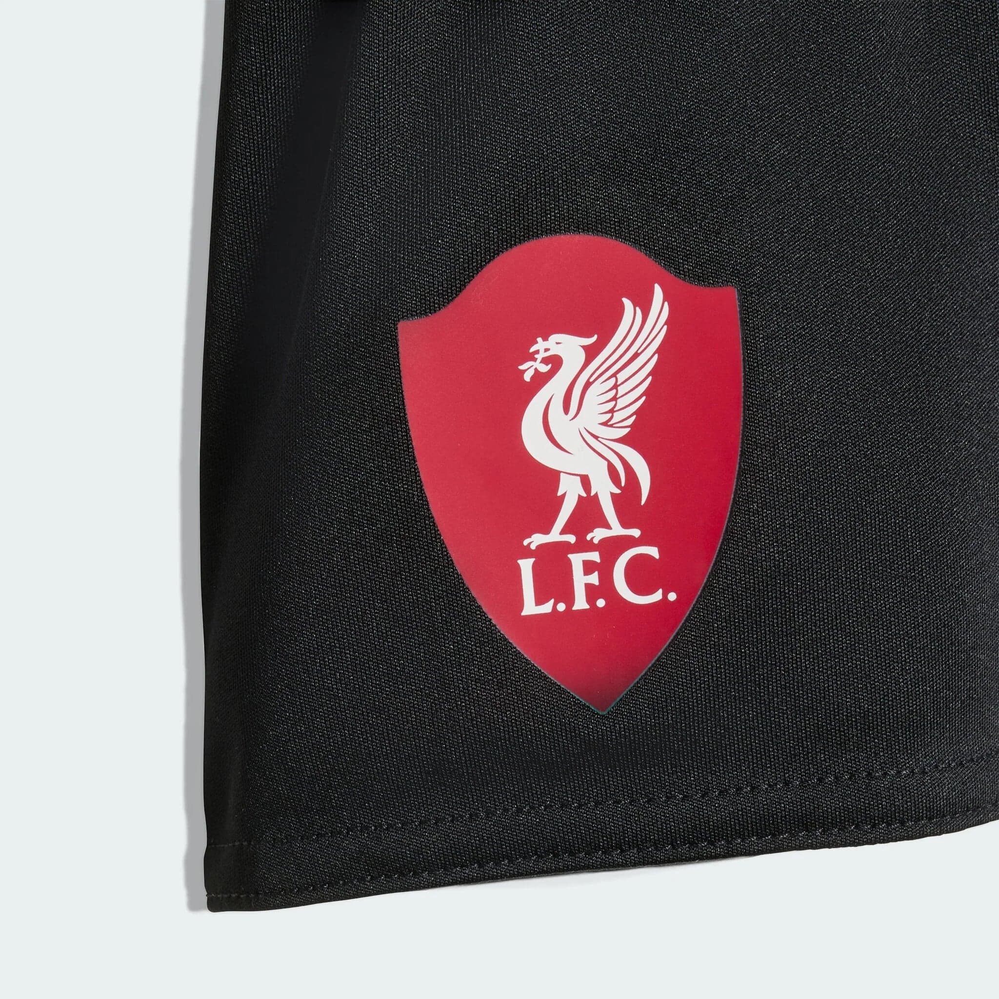 JV6462_D3_Flat_eCom-lowres | AE JERSEY Red Liverpool FC shield badge with white liverbird on dark fabric surface (likely a bag).