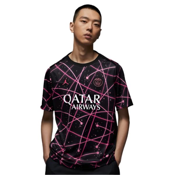 Young man wearing a black soccer jersey with pink neon grid patterns and the 'QATAR AIRWAYS' logo on the front.