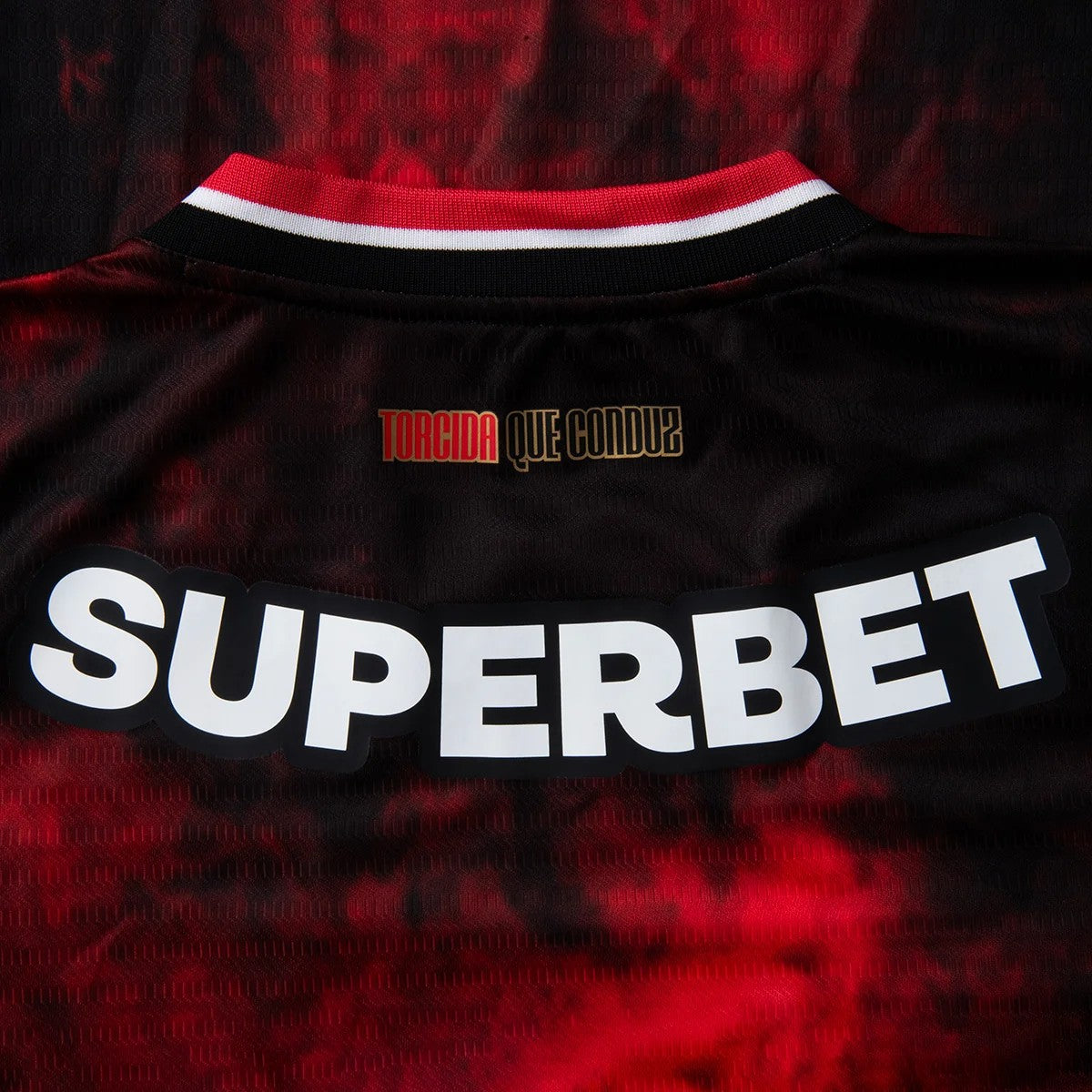 OfvlVtHsyloEeyL | AE JERSEY Back of a black and red sports jersey with a large white 'SUPERBET' sponsor and a small red 'TORCIDA QUE CONDUZ' above.