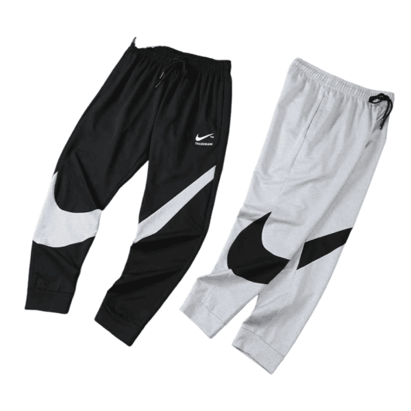 Two Nike jogger pants laid side by side: black pair with white swoosh, and light gray pair with black swoosh.