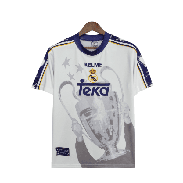 White Real Madrid jersey on a wooden hanger with purple collar, yellow trim, crest, and a large grayscale graphic of a player.