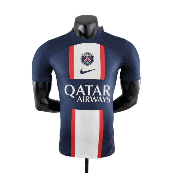 Front view of a Paris Saint-Germain football jersey on a mannequin: navy blue with white and red central panel, Nike swoosh, PSG crest, and Qatar Airways sponsor.