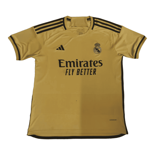 Gold Real Madrid soccer jersey with Emirates Fly Better sponsor, Adidas logo, and club crest on the chest, featuring black shoulder stripes.