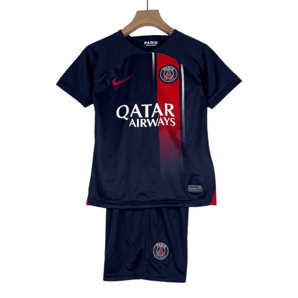 Navy Paris Saint-Germain football jersey with a red vertical stripe, sponsor logo Qatar Airways, and crest on the chest, hanging on a wooden hanger.