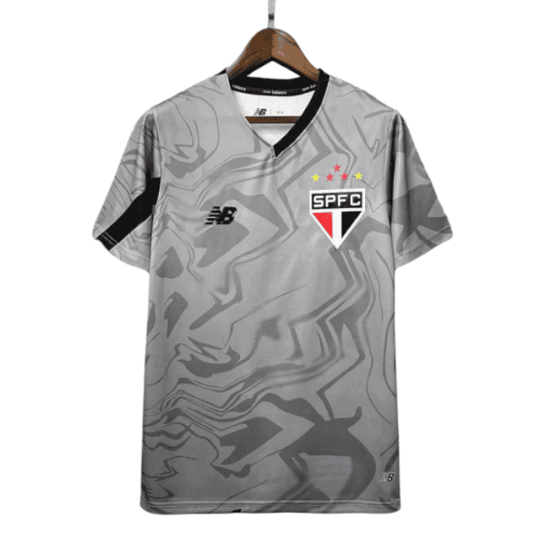 Gray camouflage São Paulo FC soccer jersey on a hanger, featuring the SPFC crest, New Balance logo, and a black shoulder stripe.