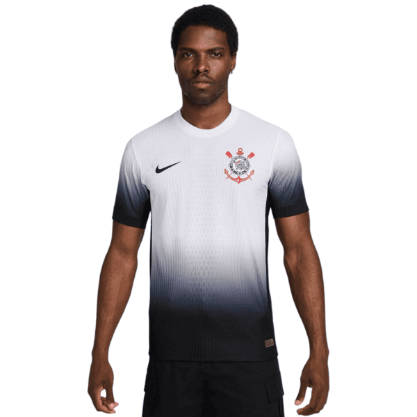 Male model wearing a white-to-navy gradient football jersey with a Nike swoosh on the left chest and a red-and-black club crest on the right chest, standing against a white background.