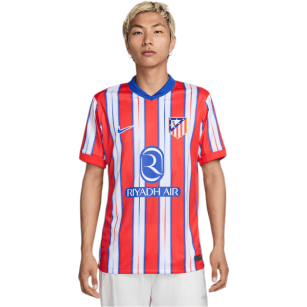 Front view of a man wearing Atlético Madrid home jersey with red and blue vertical stripes and Riyadh Air sponsor logo.