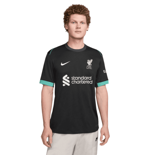 Man wearing a black Liverpool FC training shirt with the club crest and Standard Chartered sponsor logo, facing forward.]