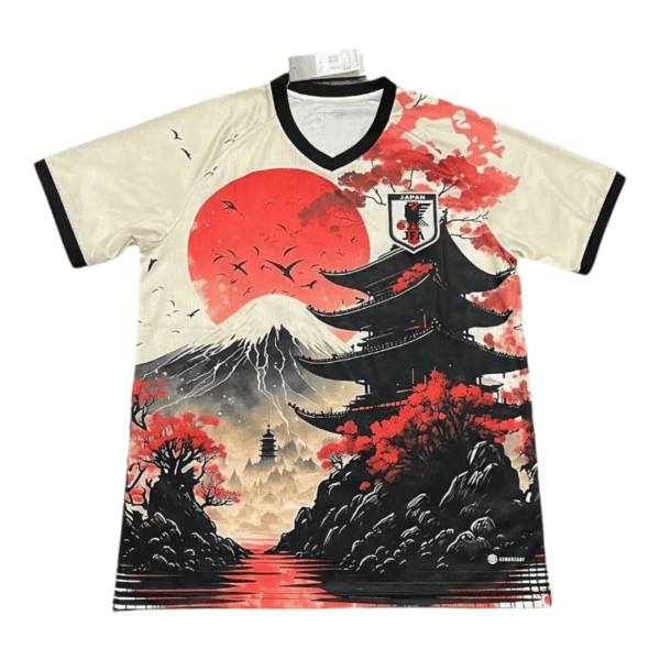Beige V-neck T-shirt with a Japan-inspired print: a large red sun, Mount Fuji, a black pagoda, red maple trees, and a river scene with a Japan Football Association crest on the chest.