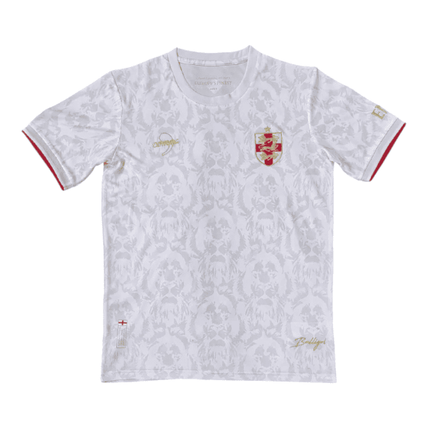 White T-shirt with a subtle grey floral/coat pattern, gold crest on the left chest and gold script details, red-trimmed sleeve cuffs.