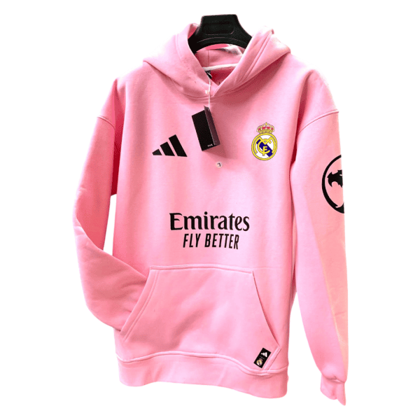 Pink Real Madrid hoodie with Emirates Fly Better branding, Adidas logo, front pocket, hanging on a black hanger.