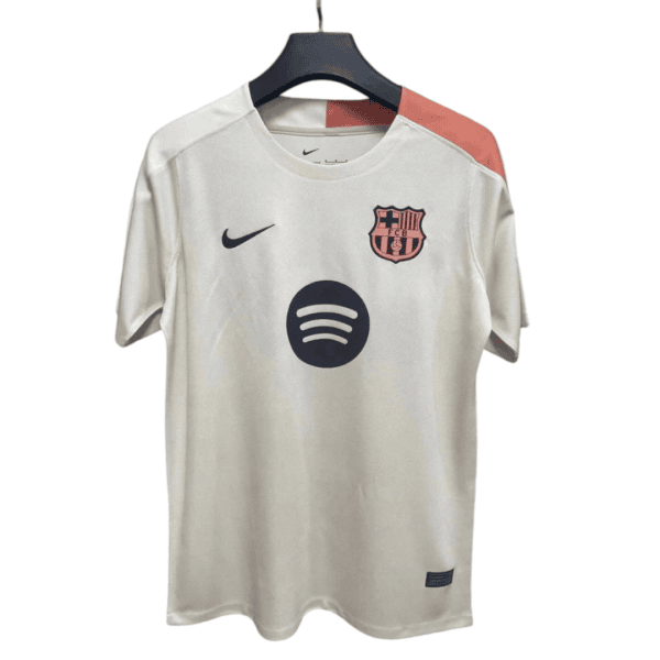 White FC Barcelona football jersey on a hanger with Nike swoosh, club crest, and Spotify sponsor logo on the chest, pink shoulder panel detail.