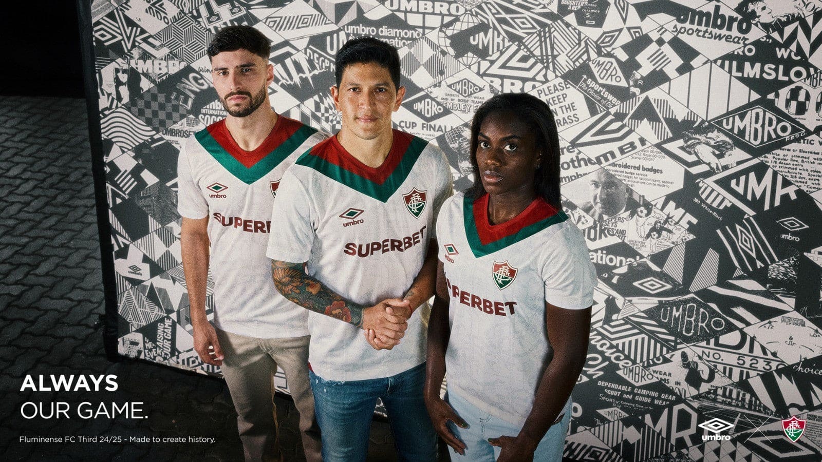 Py5Xx04dNEY038D | AE JERSEY Three soccer players in white jerseys with red and green chevrons stand together; the center player shakes hands with a teammate while the others look at the camera against a patterned wall.