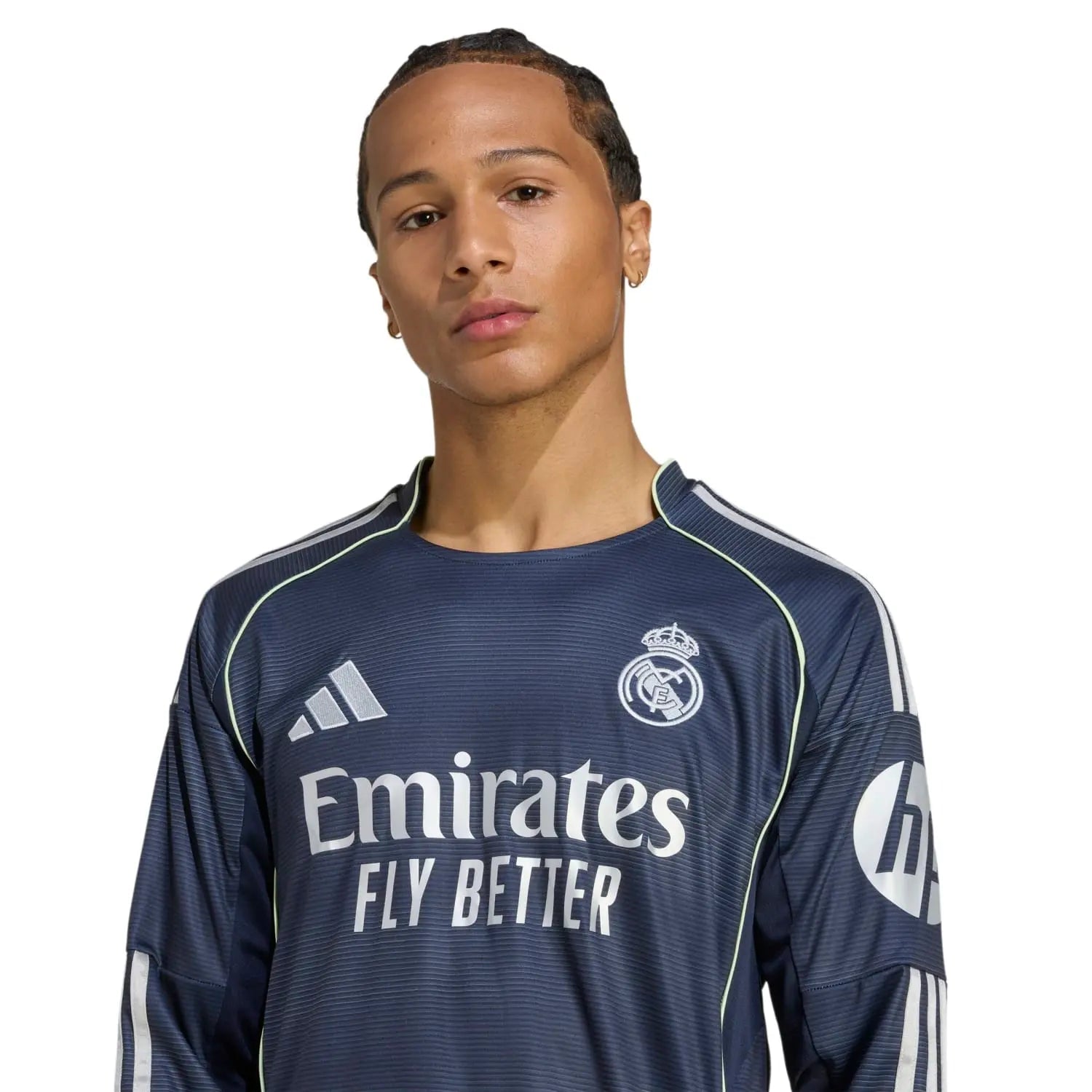 RMCFMZ0907_6 | AE JERSEY Man wearing a dark Real Madrid football jersey with 'Emirates Fly Better' slogan visible on the front.