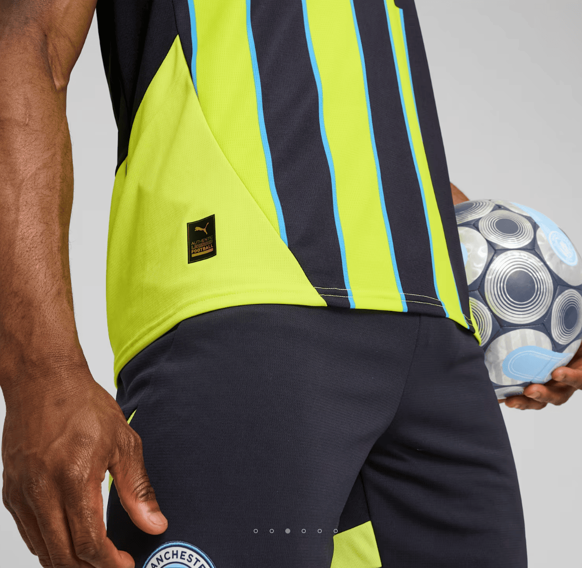 Screenshot_2024-09-04_181453 | AE JERSEY Close-up of a player in a neon yellow and navy striped jersey holding a patterned soccer ball at the side.