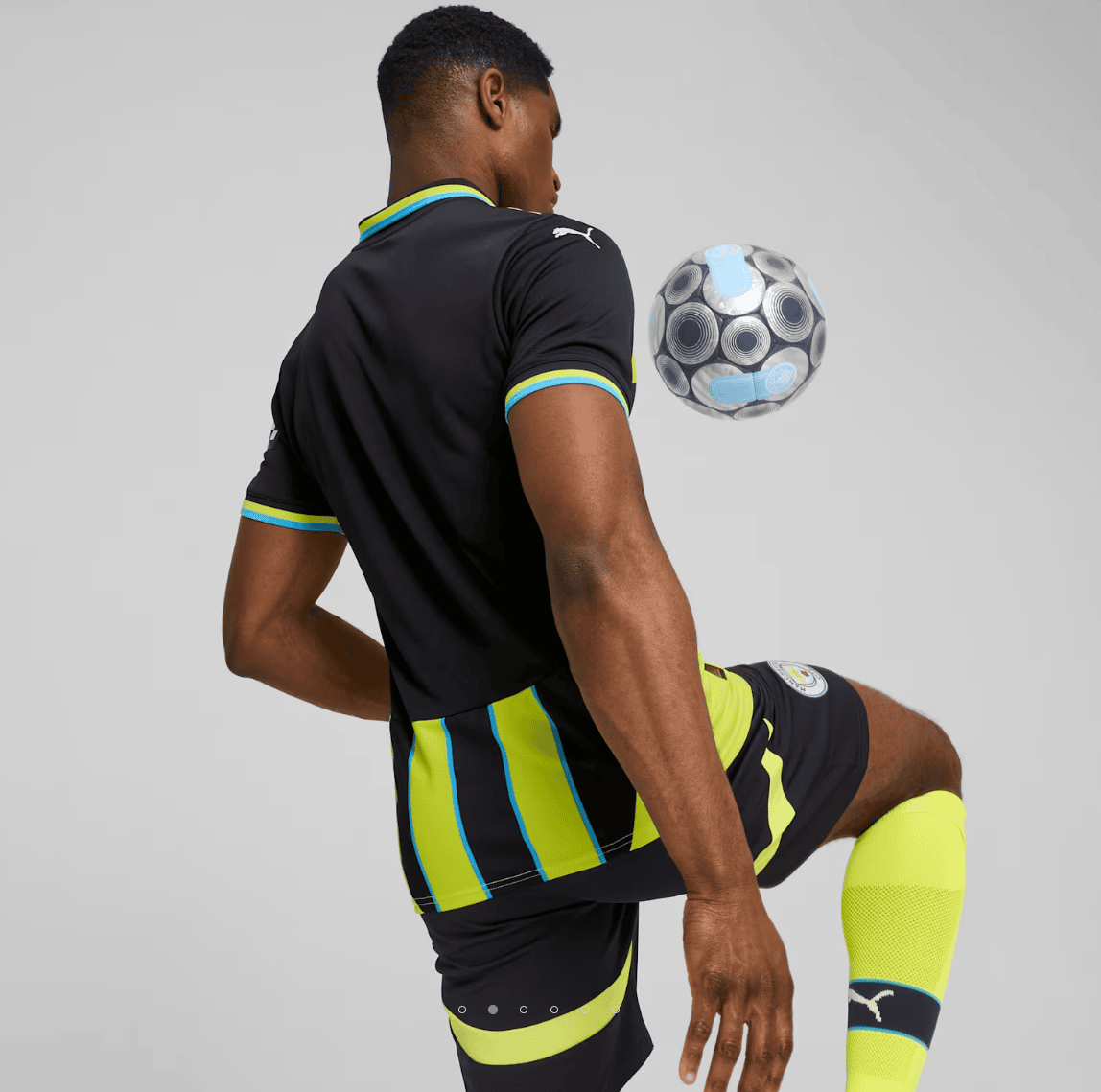 Screenshot_2024-09-04_181459 | AE JERSEY Soccer player in a dark kit with neon yellow stripes controls a patterned ball mid-air beside his leg.