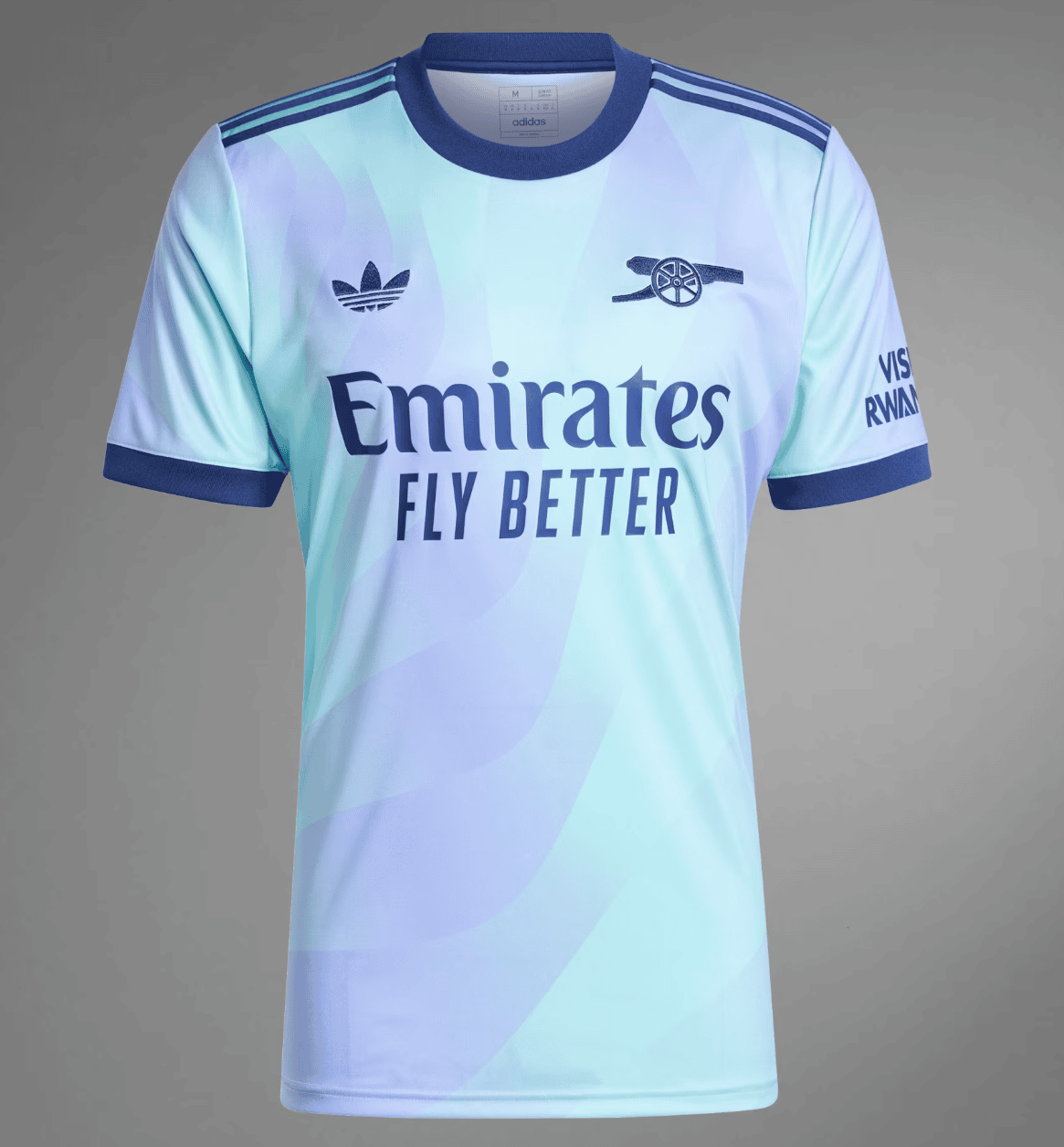 Screenshot_2024-09-18_194453_686678cf-dcc5-4ae3-a155-2ecfce0e3db3 | AE JERSEY Light blue gradient football jersey with Emirates Fly Better sponsor, Adidas stripes on shoulders, and a cannon emblem on the chest.