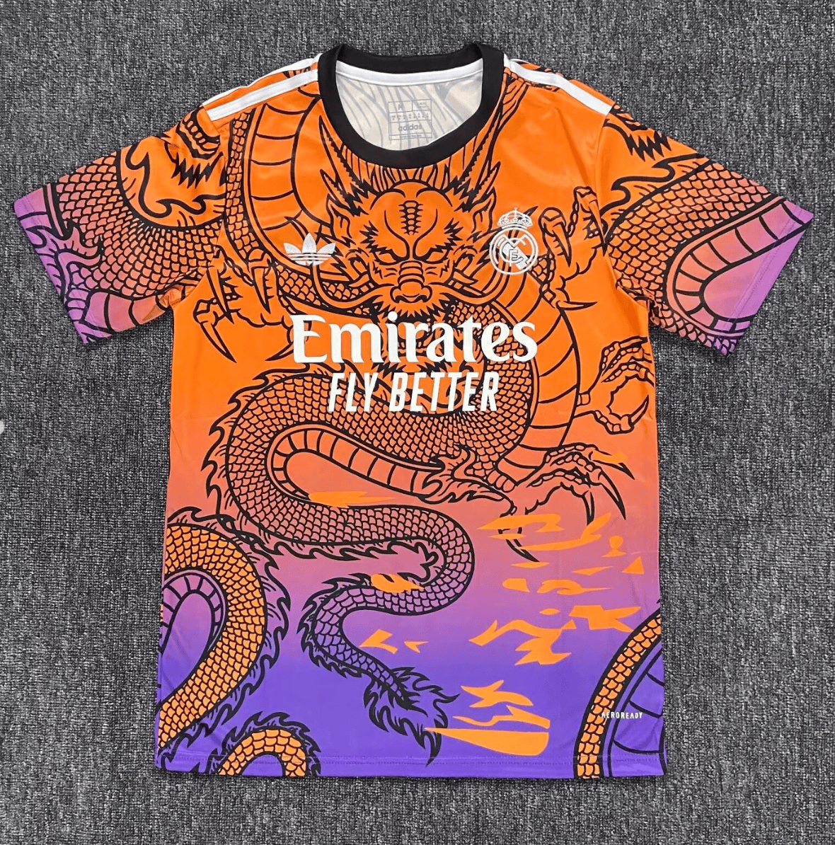 Screenshot_2024-12-10_183802 | AE JERSEY Orange-to-purple Real Madrid football jersey with a black collar and bold dragon graphic, featuring Emirates Fly Better sponsor logo.