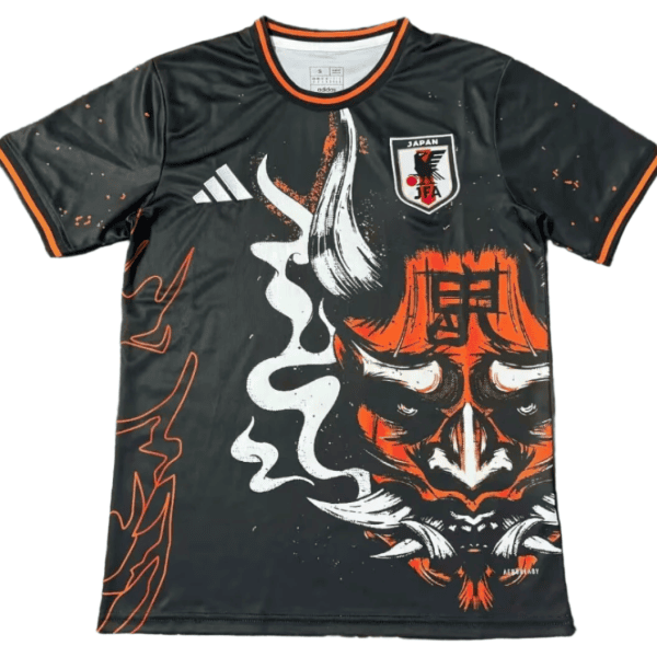 Black soccer jersey with orange trim and a large orange demon mask graphic, Japan IFA crest on the chest.
