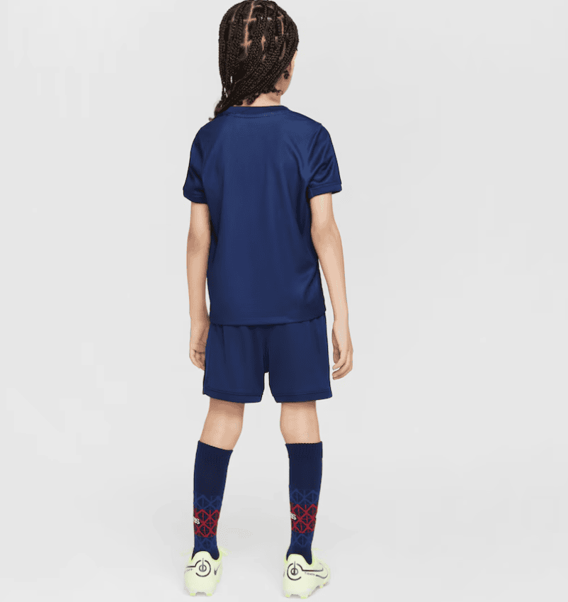 Screenshot_2025-06-23_232320 | AE JERSEY Back view of a child in a navy soccer kit: jersey, shorts, knee-high navy socks with red geometric pattern, and light-green cleats