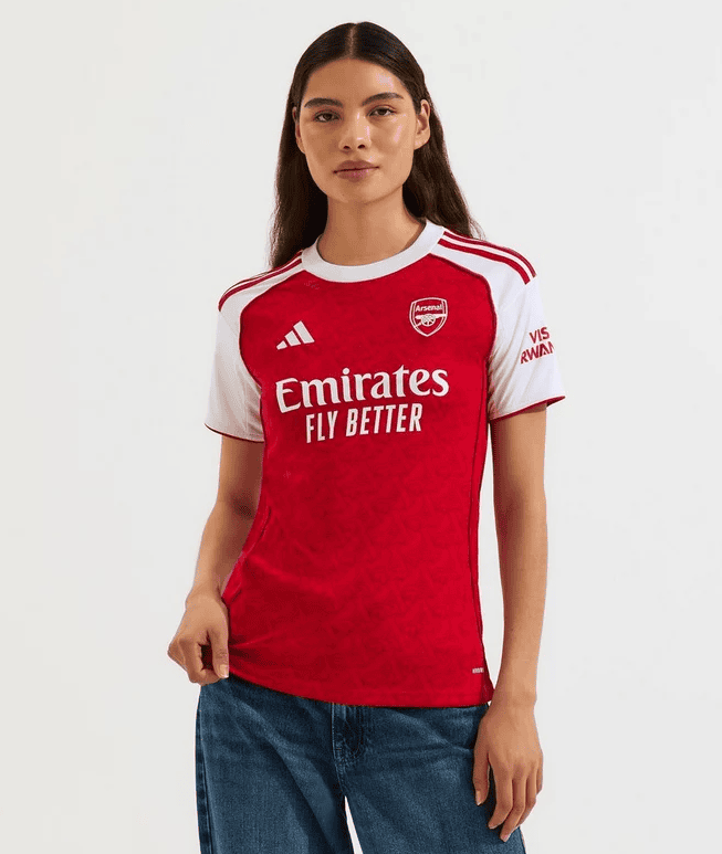 Screenshot_2025-06-25_051420 | AE JERSEY Woman wearing Arsenal red and white home jersey with Emirates Fly Better logo and club crest, posing against a light background.