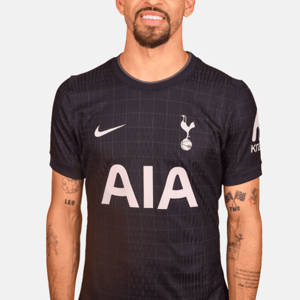 Man wearing a black Tottenham Hotspur football jersey with AIA sponsor across the chest and Nike logo on the right