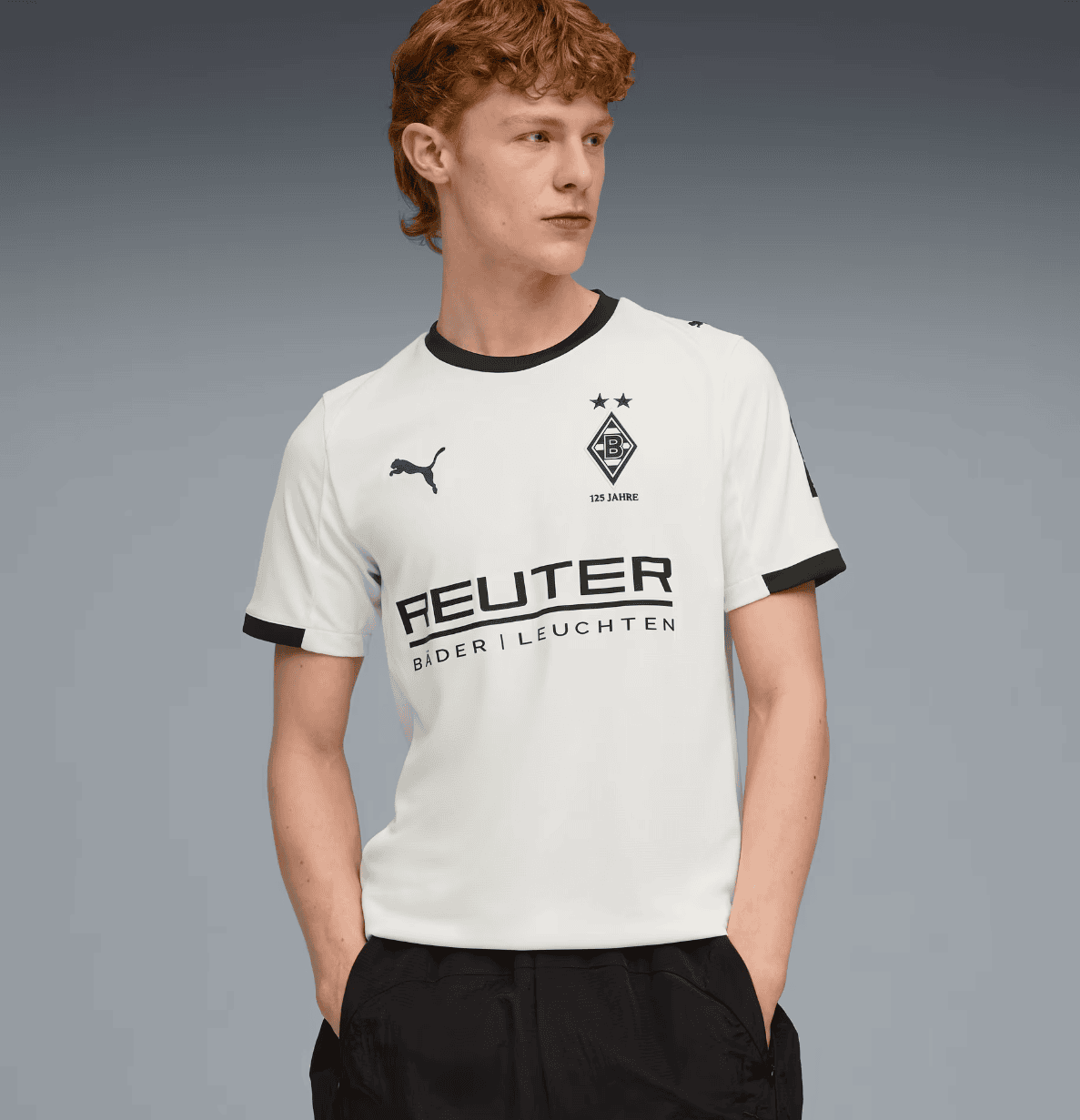 Screenshot_2025-07-16_205607 | AE JERSEY Young man wearing a white Borussia Dortmund football jersey with black trim and sponsor logo, standing with hands in pockets.