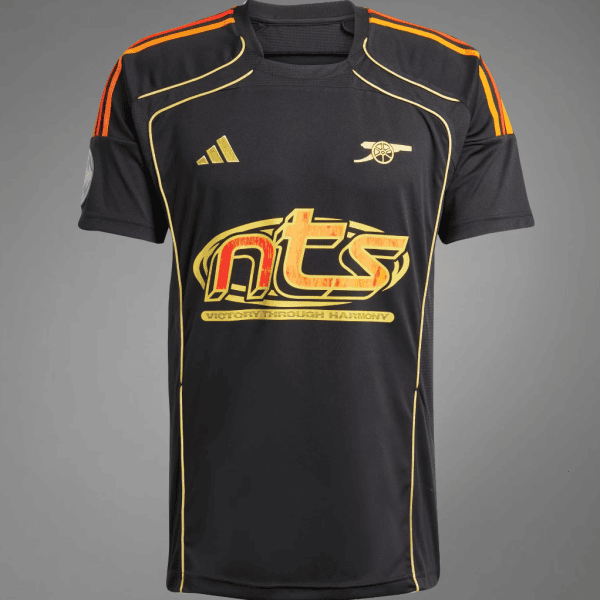 Black athletic jersey with orange shoulder piping and gold trim, featuring a large red-yellow 'nts' logo across the chest and a gold emblem on the left chest area.