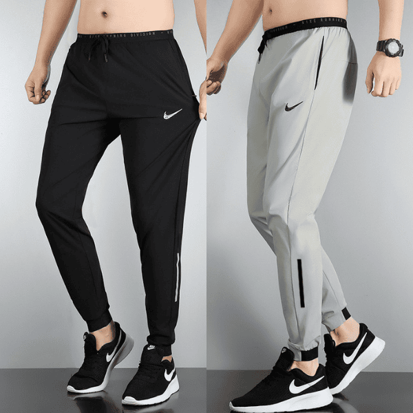 Side-by-side view of two men's Nike jogger pants: black pair on the left and light gray pair on the right, with logo and zip pockets visible.