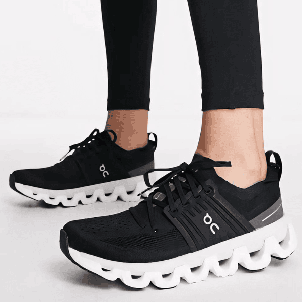 Black On brand running shoes with a white sculpted sole and laced upper in a side view.
