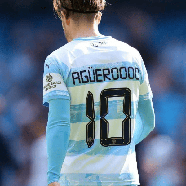 Back view of a soccer player wearing a Manchester City kit with the name 'AGUERO' and number 10 on the jersey.