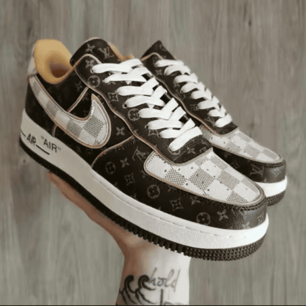 Pair of brown and white patterned sneakers with white laces, held in a hand.