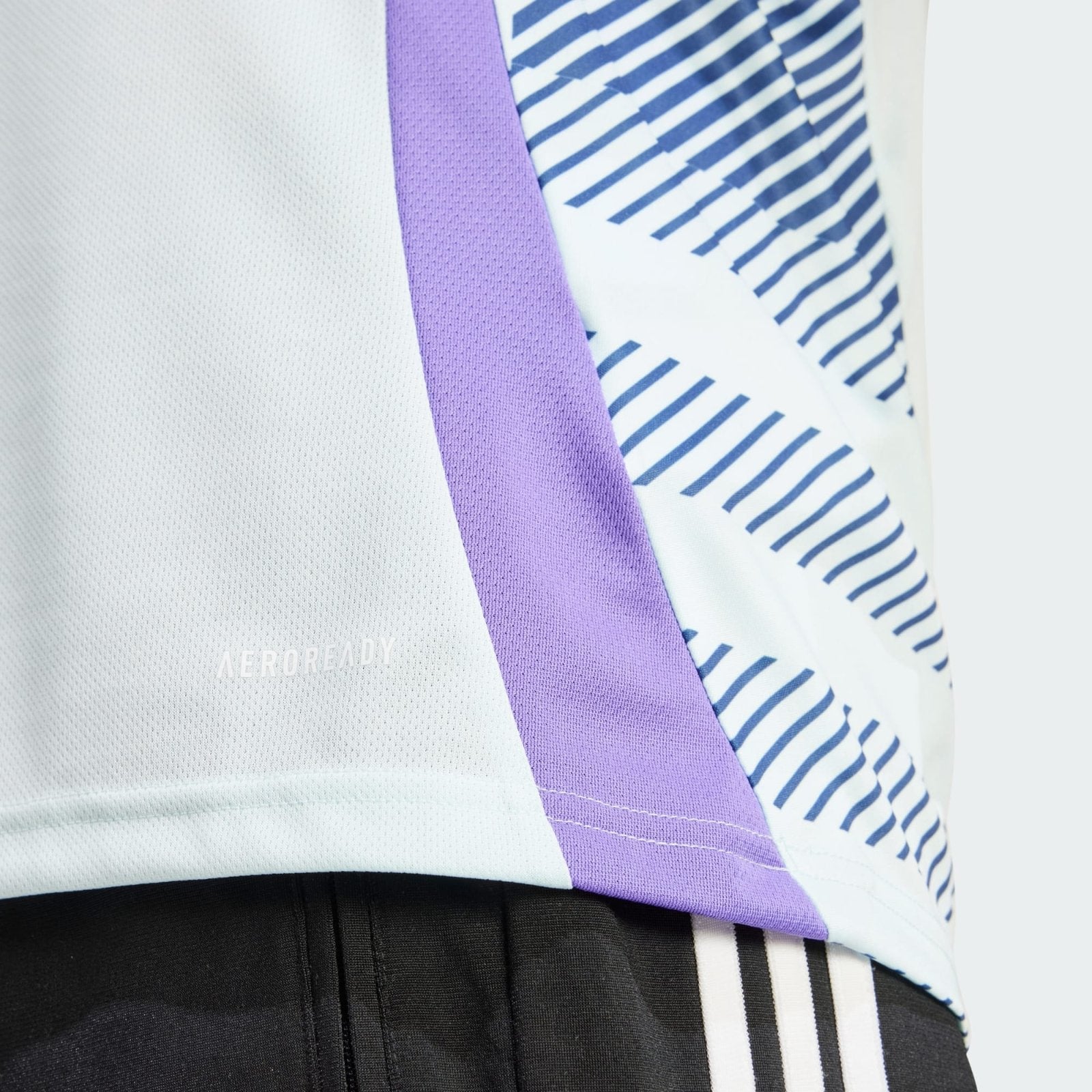VhbeZo9qVvGbUzu | AE JERSEY Close-up of a white textured dress shirt with a purple tie and a blue-and-white striped shirt, paired with black trousers and a striped belt.