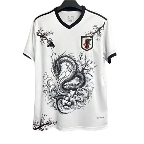 White soccer jersey with black trim featuring a large black dragon graphic and Japan JFA crest on the chest.