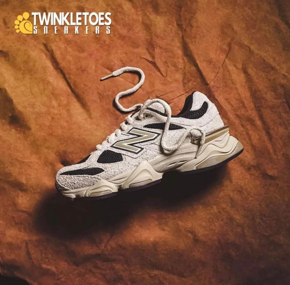 WhatsApp_Image_2024-07-27_at_01.11.40 | AE JERSEY White/gray athletic sneaker on a brown textured backdrop with Twinkletoes Sneakers logo in the corner, product shot.