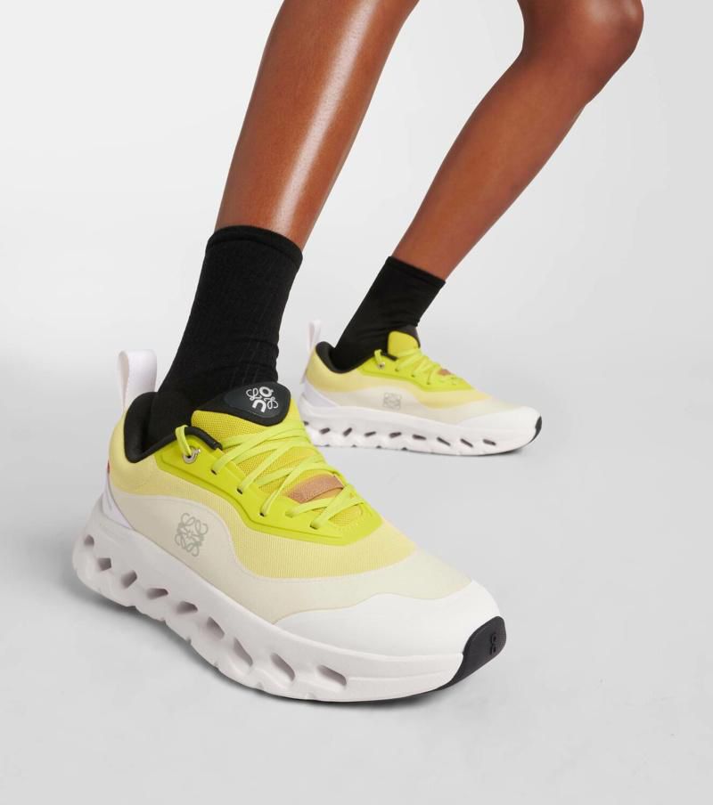 WhatsApp_Image_2024-09-09_at_09.47.28 | AE JERSEY Close-up of a person wearing bright yellow athletic sneakers with chunky white soles, and black socks, shown from the side.