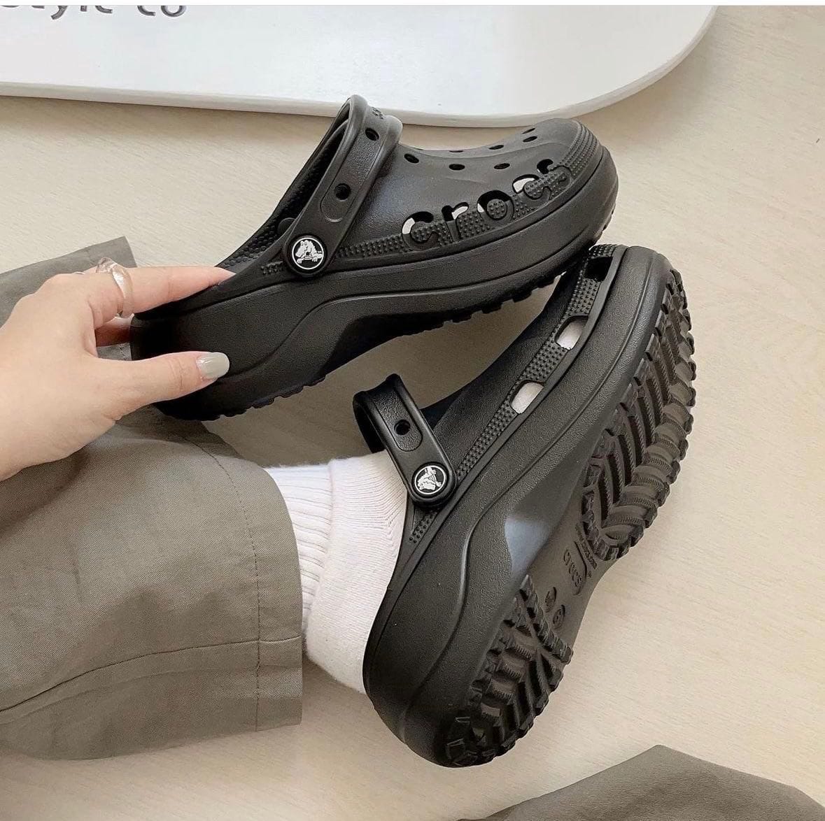 WhatsApp_Image_2024-10-19_at_11.33.54 | AE JERSEY Black platform Crocs-style clogs with back strap, worn by a person, on a light wooden floor.
