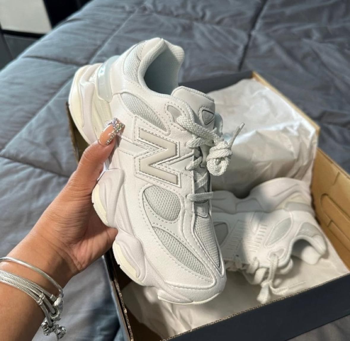 WhatsApp_Image_2024-10-25_at_12.39.04_1 | AE JERSEY White chunky sneaker held in hand with another shoe and box visible in the background on a bed.