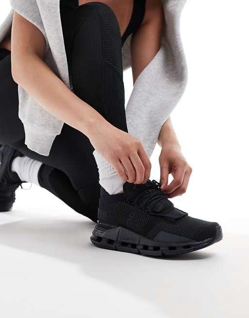 WhatsApp_Image_2024-11-06_at_11.22.32 | AE JERSEY Person kneeling and tying black athletic sneakers, wearing white socks and a gray hoodie.