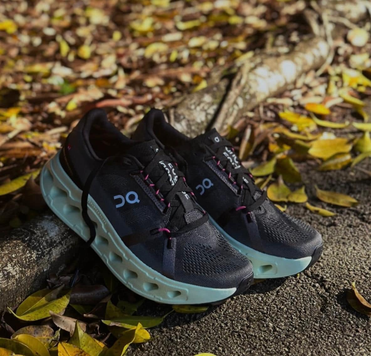 WhatsApp_Image_2025-01-19_at_11.59.14 | AE JERSEY Pair of black running shoes with thick light-blue soles resting on a curb among fallen autumn leaves.