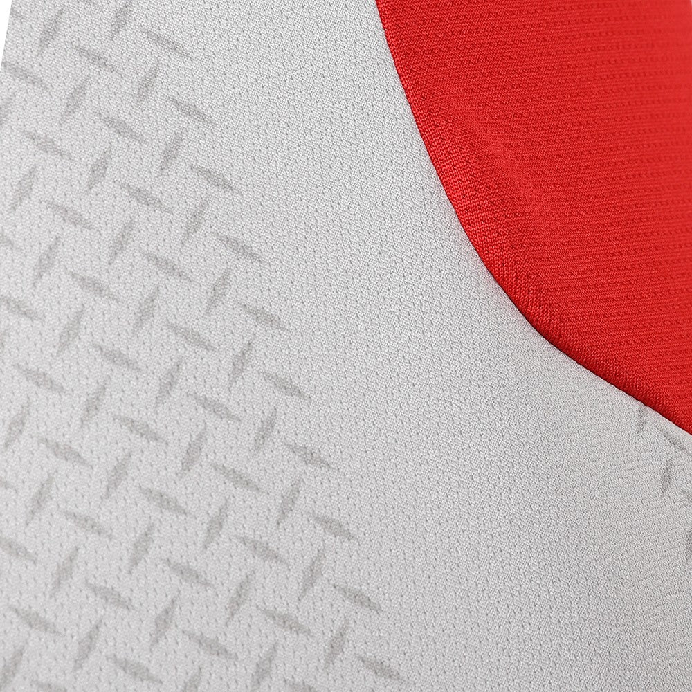 XjbPjcl5IMXgZYu_ef3c4710-4c29-4706-90c9-70e82a9d3fb4 | AE JERSEY Close-up of light gray fabric with a repeating diamond texture and a red curved edge/section.