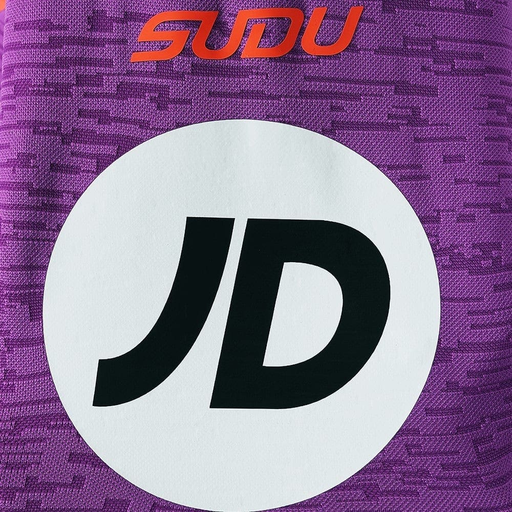 YQdWZeW9qjc1jGh | AE JERSEY Close-up of a purple patterned jersey with a white circle containing a black 'JD' logo and orange 'SDU' text above.