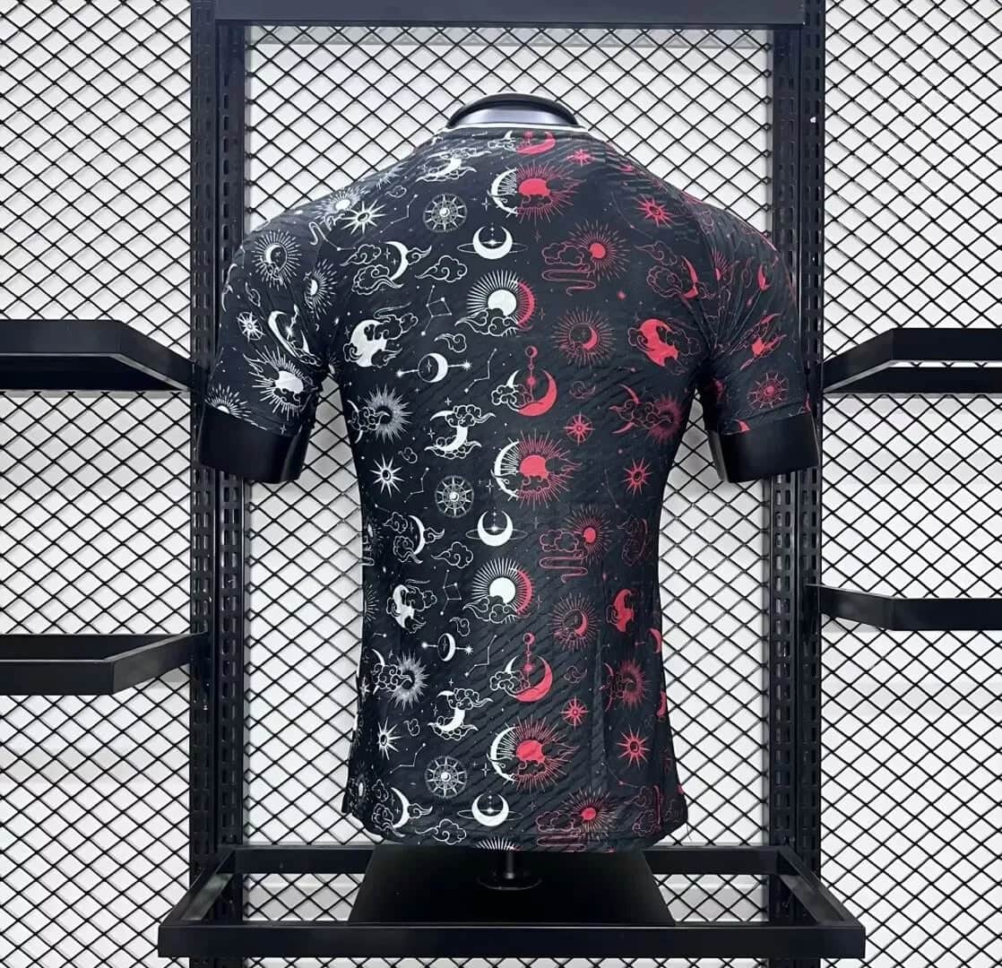 a47f5cd7c4d16792 | AE JERSEY Black short-sleeve shirt with white and red sun, moon, and star patterns on a mannequin in a metal grid display.