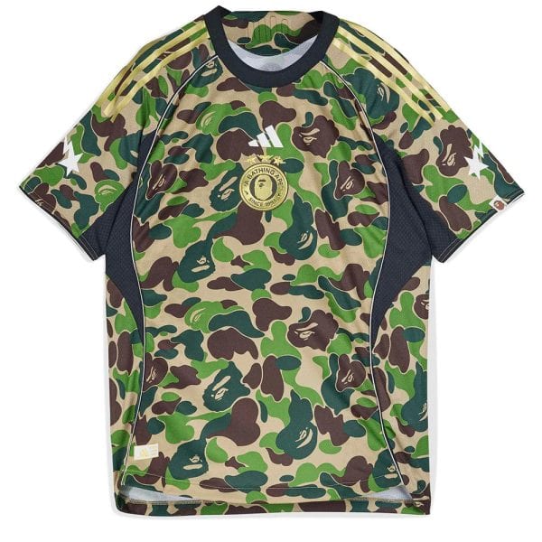 Camouflage-pattern athletic jersey with a round gold emblem at the chest and white Adidas-like stripes on the shoulders; short sleeves and dark trim around the neck and sides.