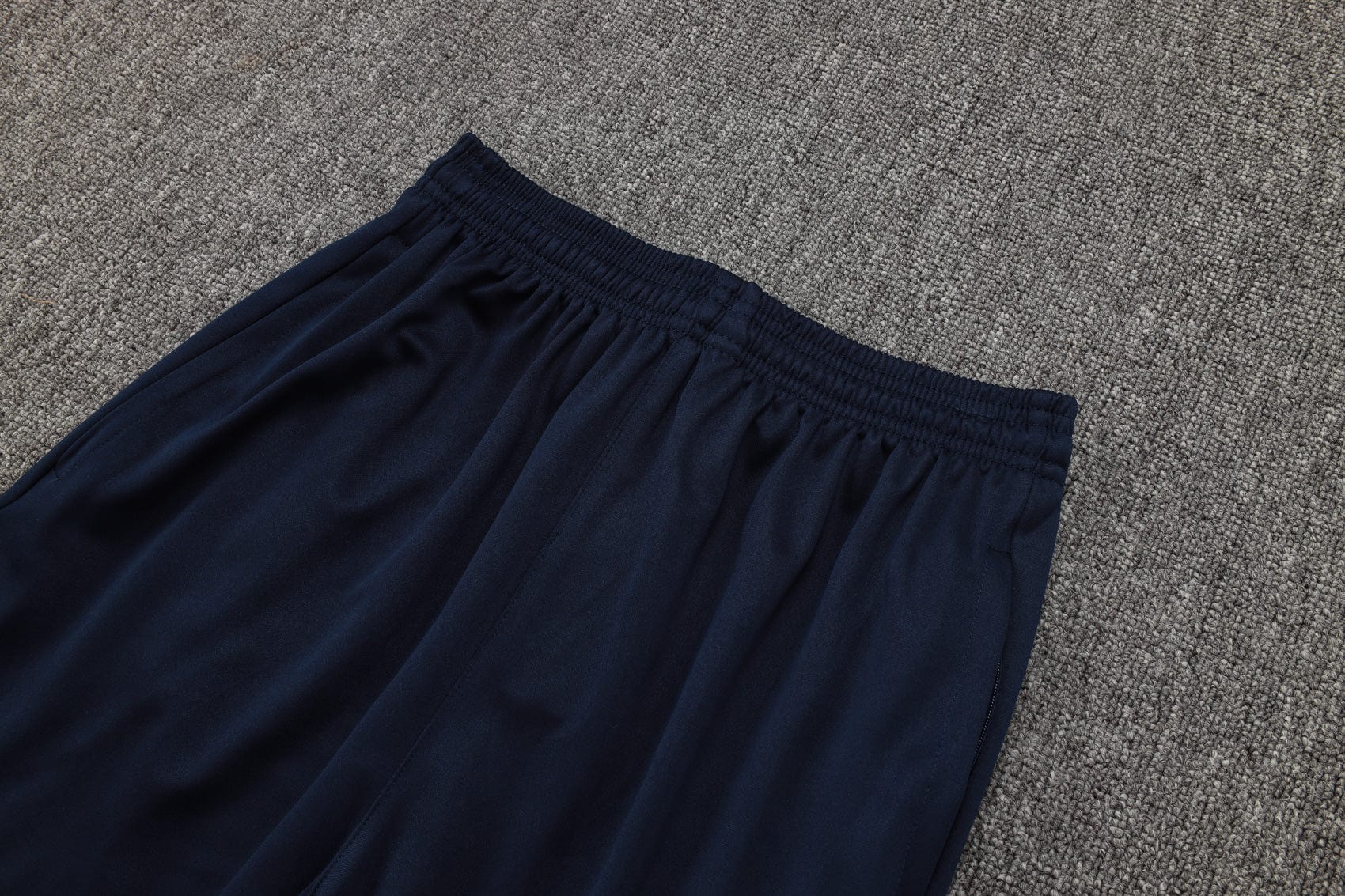 b050131e | AE JERSEY Navy blue elastic-waisted pants laid on a gray carpet, showing gathered waistband and soft fabric edge.