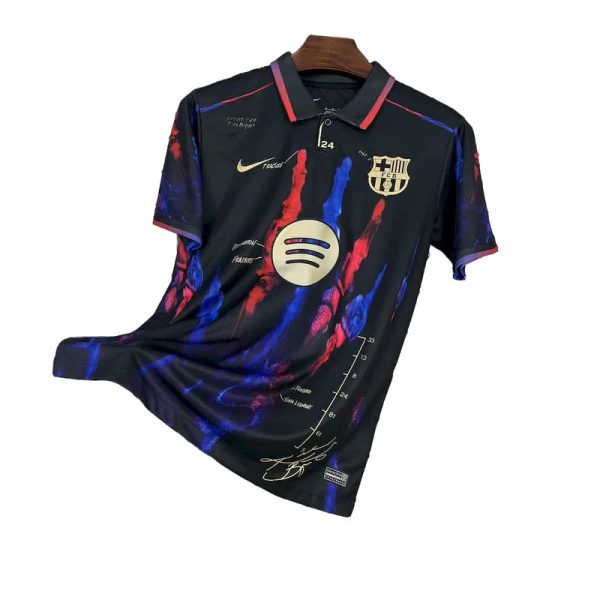 Black FC Barcelona jersey with blue and red brush strokes, Nike swoosh, Barça crest, and Spotify circular logo on the chest.